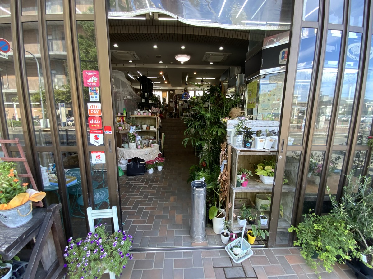 花に囲まれた店舗の入口